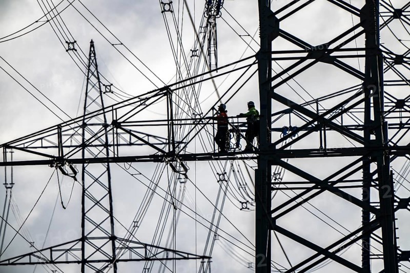 Work on a 380 kV high-voltage overhead line, new construction, along the A57 motorway, near Meerbusch, workers on the boom of the high-voltage pylon, North Rhine-Westphalia, Germany