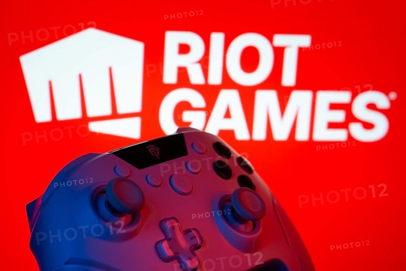 Dhaka, Bangladesh- 14 Nov 2025: A close-up of a gamepad with the Riot Games seen on screen in the background