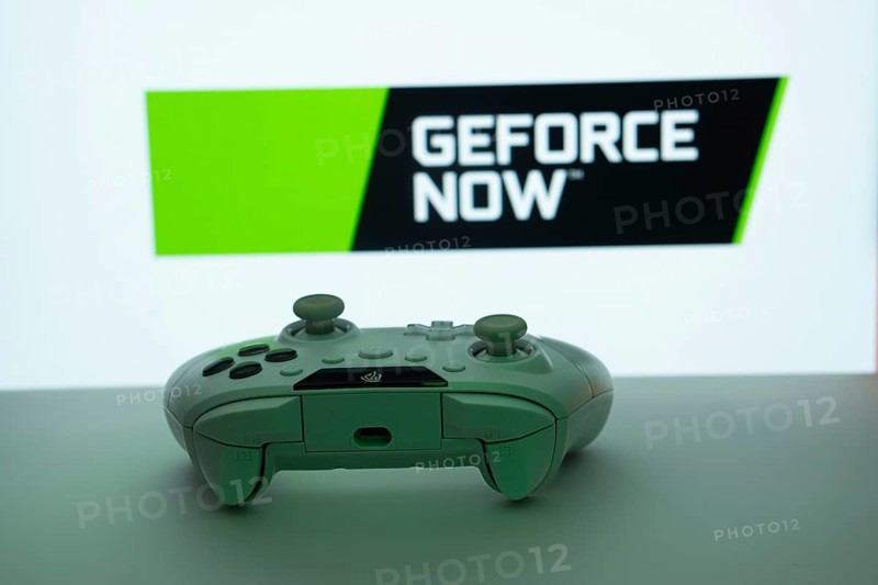 Dhaka, Bangladesh- 14 Nov 2025: A close-up of a white gamepad with the Geforce Now seen on screen in the background