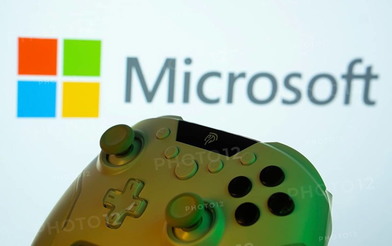 Dhaka, Bangladesh- 14 Nov 2025: A close-up of a gamepad with the Microsoft seen on screen in the background