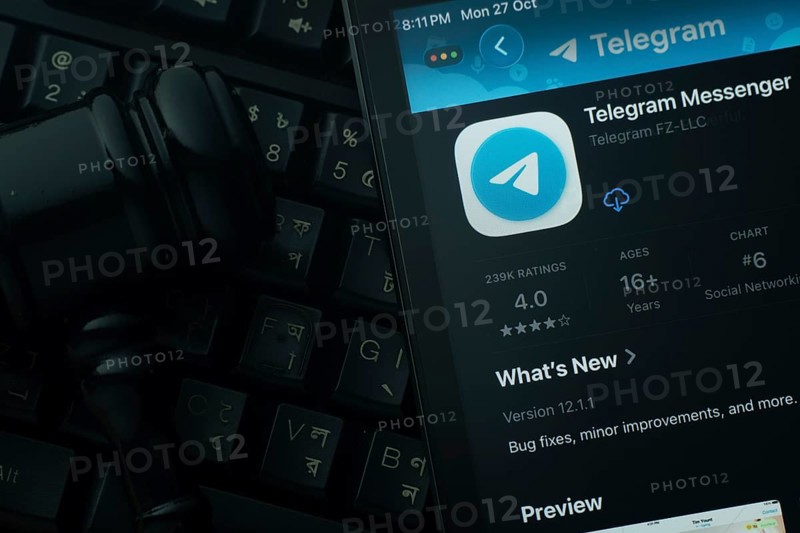 Dhaka, Bangladesh- 28 Oct 2025: An iPad displaying the Telegram app against a judge's gavel and dark keyboard background