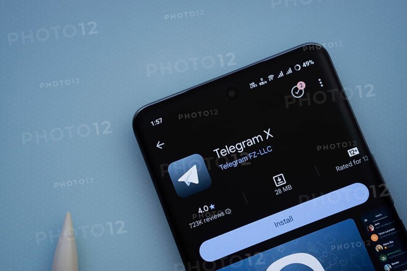 Dhaka, Bangladesh- 29 May 2025: On a blue surface, a smartphone displays the Telegram X app within the Google Play Store