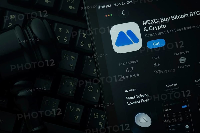 Dhaka, Bangladesh- 28 Oct 2025: An iPad displaying the MEXC app against a judge's gavel and dark keyboard background