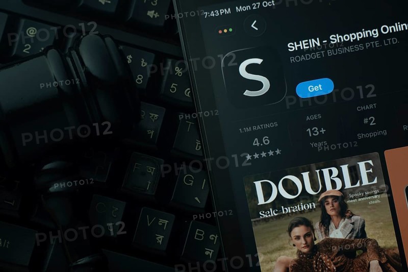 Dhaka, Bangladesh- 28 Oct 2025: An iPad displaying the SHEIN app against a judge's gavel and dark keyboard background