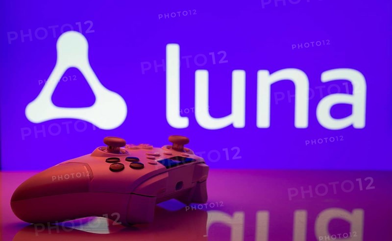 Dhaka, Bangladesh- 14 Nov 2025: A close-up of a white gamepad with the Amazon Luna seen on screen in the background