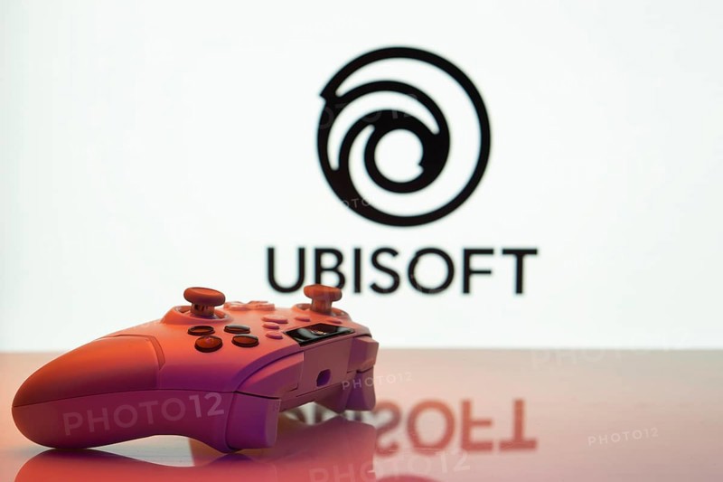 Dhaka, Bangladesh- 14 Nov 2025: A close-up of a white gamepad with the Ubisoft seen on screen in the background