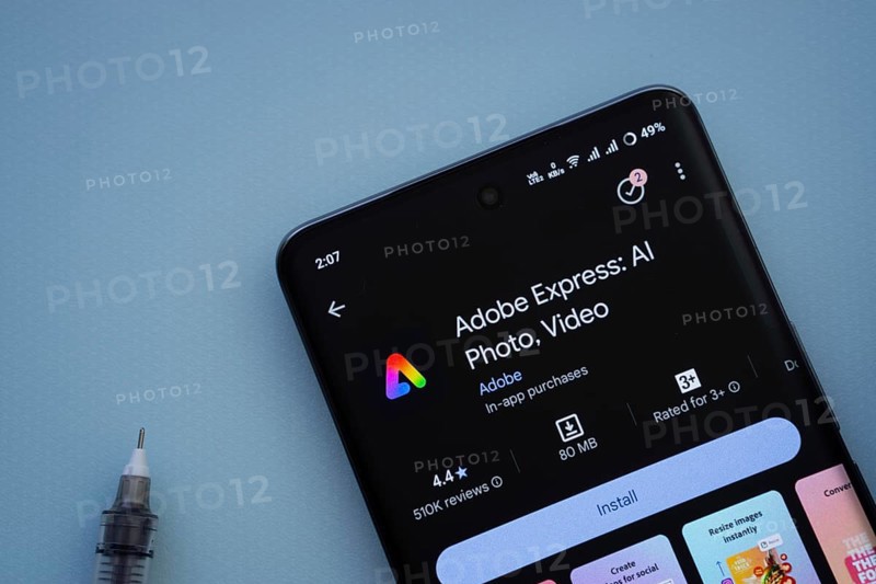 Dhaka, Bangladesh- 29 May 2025: On a blue surface, a smartphone displays the Adobe Express app within the Google Play Store