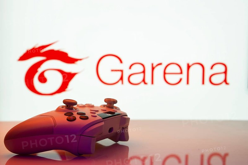 Dhaka, Bangladesh- 19 Sep 2025: A close-up of a white gamepad with the Garena seen on screen in the background
