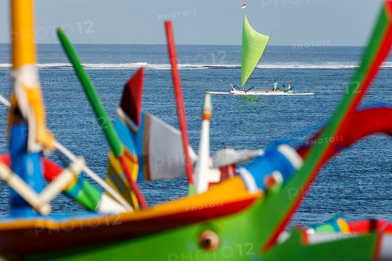 Colourfully painted outrigger fishing boats, (Junkung), on Sanur beach, Bali, Indonesia