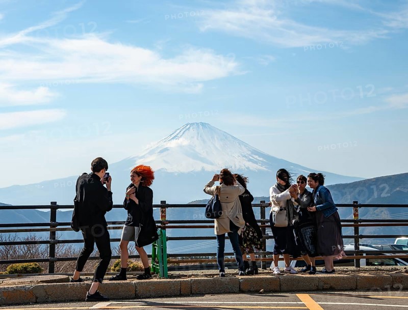 Tourists enjoy the view and take pictures, view of the snow-covered summit of Mount Fuji volcano in spring, Owakudani, Hakone, Japan