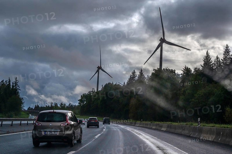 Tourist traffic on the A9 motorway during thunderstorms, wind turbines in the pine forest in the back, Bavarian Forest, Bavaria, Germany