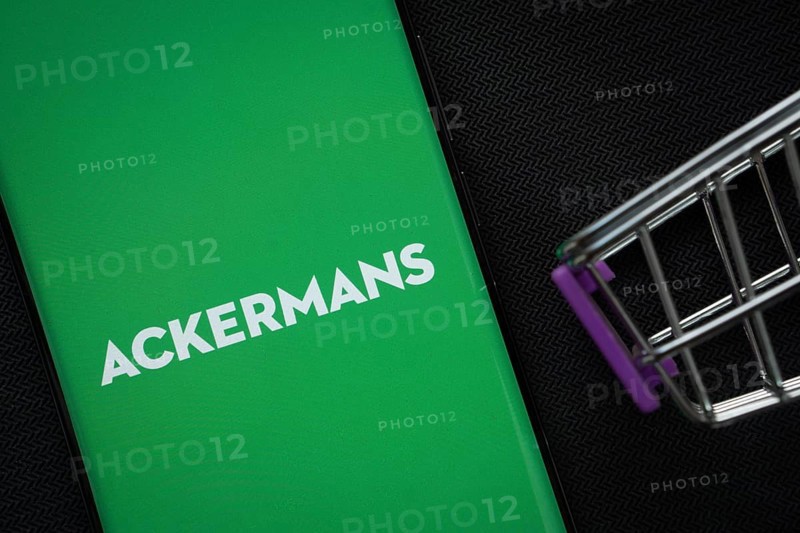Dhaka, Bangladesh- 03 July 2025: A smartphone displaying the Ackermans logo next to a miniature shopping cart on a background