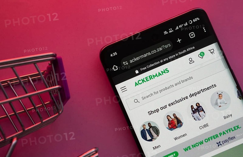 Dhaka, Bangladesh- 23 June 2025: A smartphone displaying the Ackermans website with a shopping cart is shown on a vibrant background