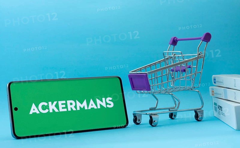 Dhaka, Bangladesh- 03 July 2025: Smartphone with Ackermans logo next to a small shopping cart and boxes against a blue background