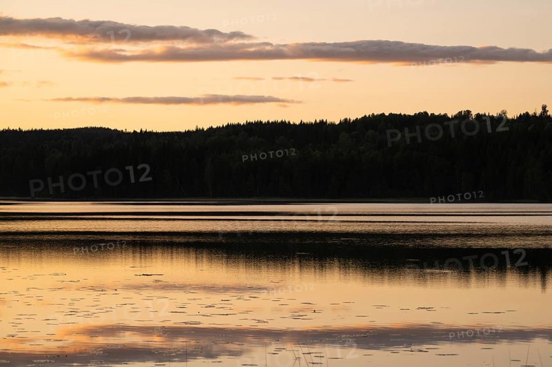 Clouds reflected on the water surface, forest lake, evening mood, at Sunne, Sweden