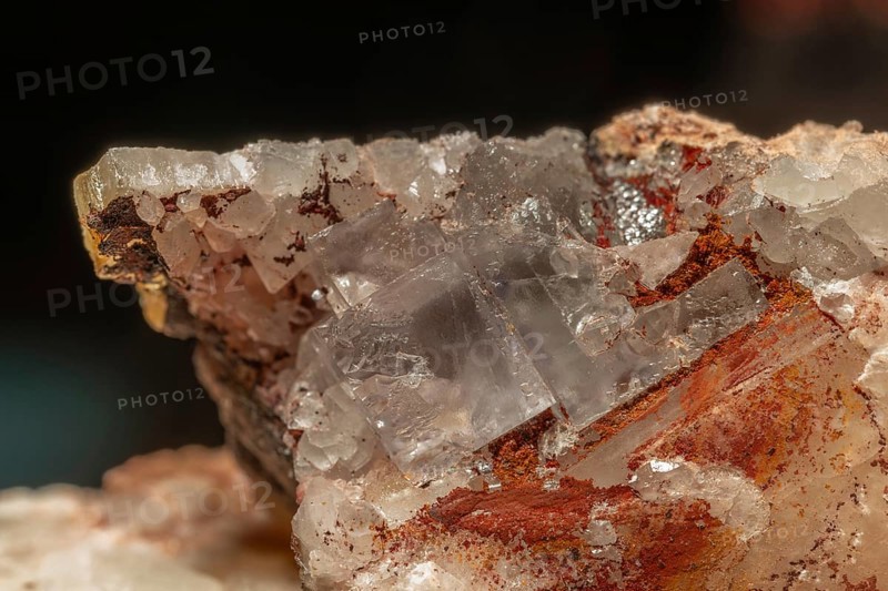 Transparent crystals sit on rocks and reveal their unique shimmer and geological structure. The light underlines the natural beauty of minerals. Bas Rhin, Alsace, France