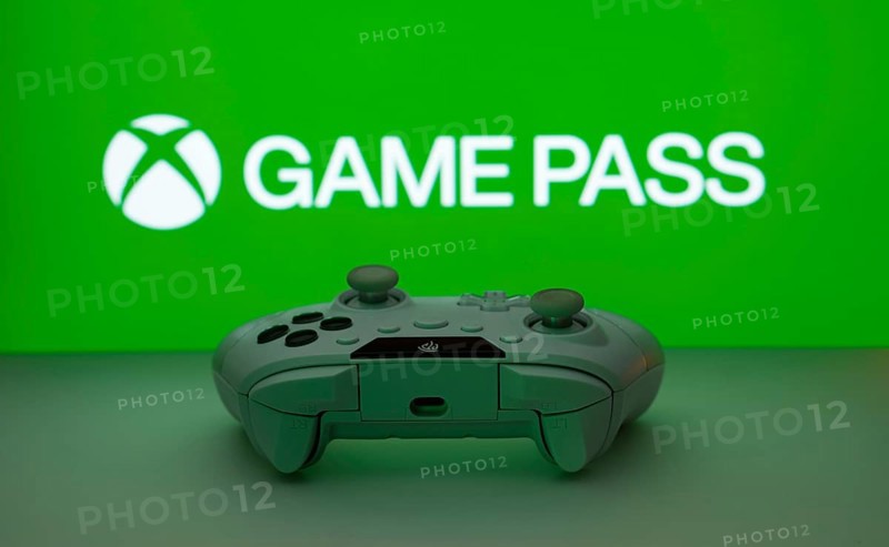 Dhaka, Bangladesh- 19 Sep 2025: A close-up of a white gamepad with the Xbox Game Pass seen on screen in the background