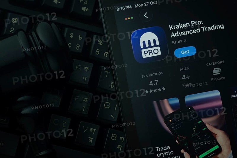 Dhaka, Bangladesh- 28 Oct 2025: An iPad displaying the Kraken Pro app against a judge's gavel and dark keyboard background
