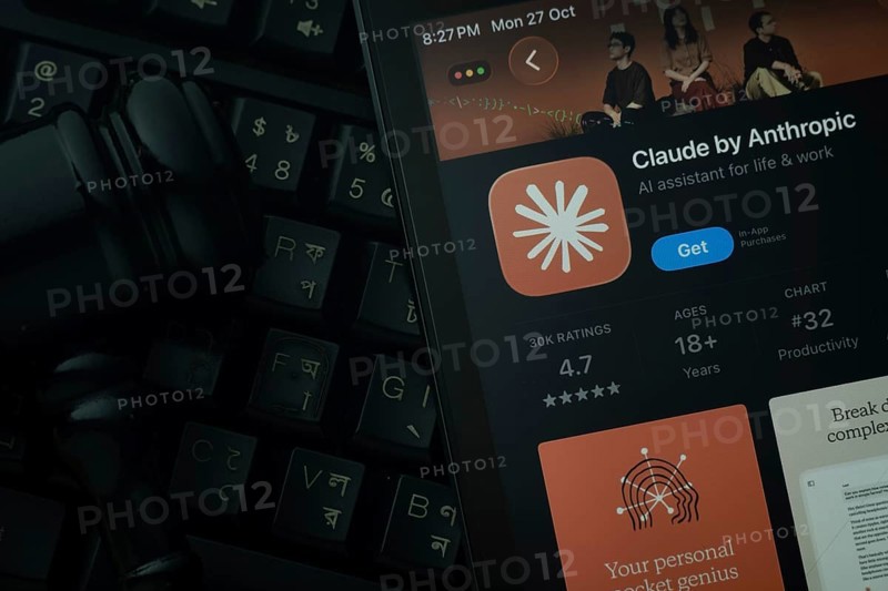Dhaka, Bangladesh- 28 Oct 2025: An iPad displaying the Claude AI app against a judge's gavel and dark keyboard background