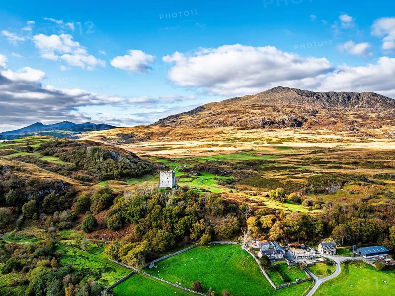 Autumn colours over Castell Dolwyddelan and Eryri Mountains from a drone, Snowdonia, Conwy County Borough, Wales, England, United Kingdom