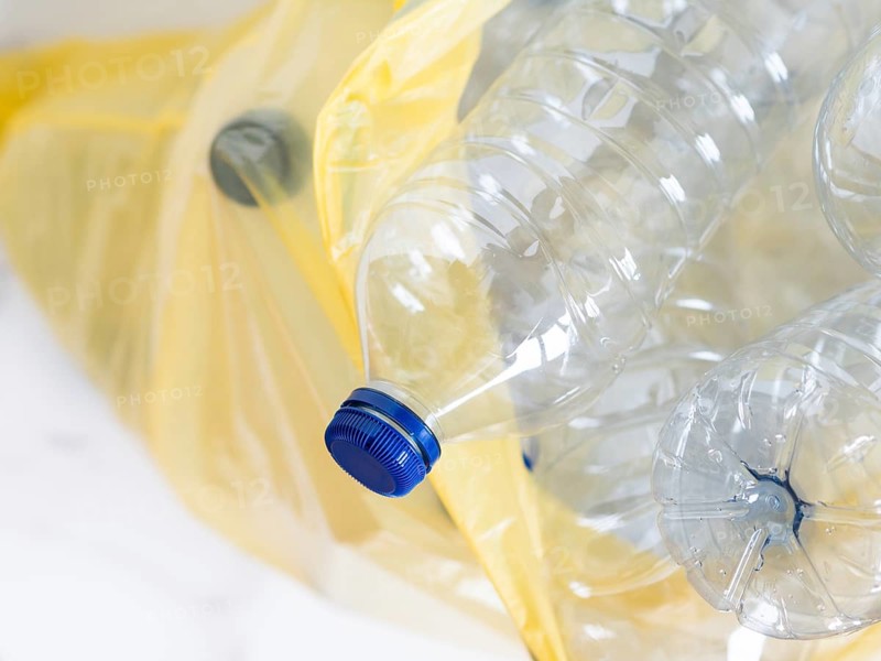 Plastic bottles inside a yellow trash bag awaiting recycling, promoting environmental responsibility and waste management