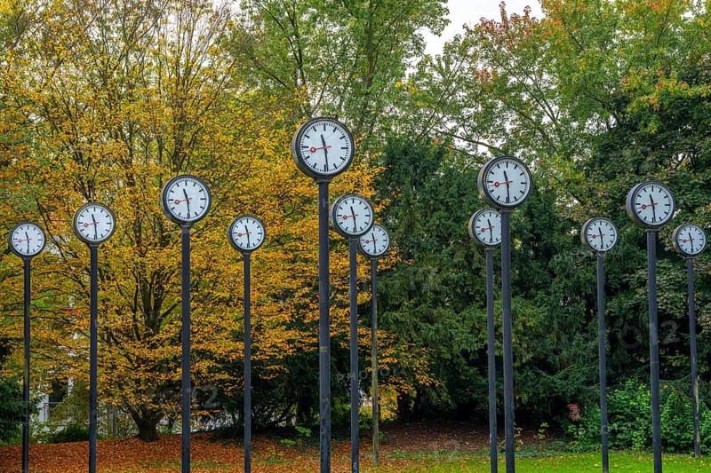 The art installation Zeitfeld in Volksgarten Park in Düsseldorf-Oberbilk, a total of 24 station clocks, on 6 meter high steel columns, have been running synchronously since 1987, artwork by Düsseldorf artist Klaus Rinke, symbol of time, time change, North Rhine-Westphalia, Germany