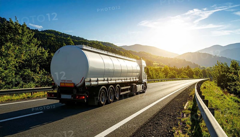 Petrol cargo truck lorry tanker driving on highway hauling oil products at sunrise, wide hilly landscape, AI generated