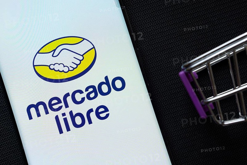 Dhaka, Bangladesh- 03 July 2025: A smartphone displaying the Mercado Libre logo next to a miniature shopping cart on a background