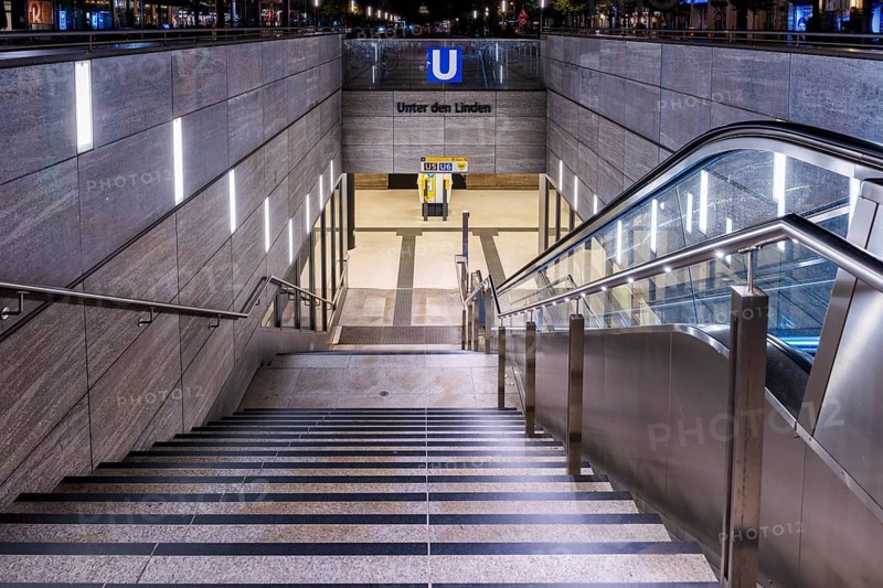 Night photo, long exposure with motion blur, modern underground entrance at Unter den Linden station, contemporary design with stairs and escalator, Berlin, Germany