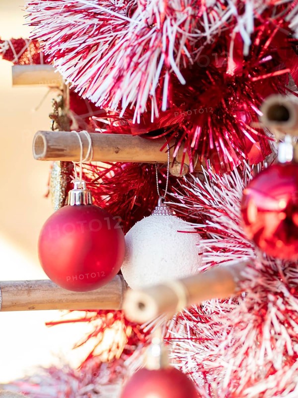 Red and white baubles decorating a festive bamboo christmas tree, celebrating holiday season