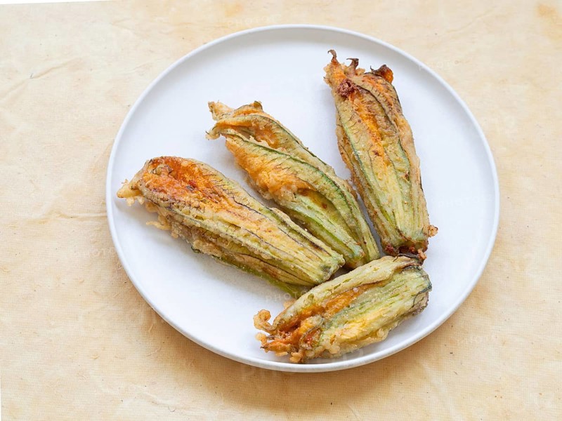 Zucchini flowers fried and stuffed on a plate offering a gourmet snack