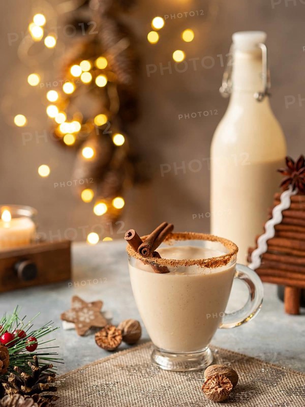 Creamy eggnog drink serving with cinnamon, nutmeg, and festive decor for holiday celebrations
