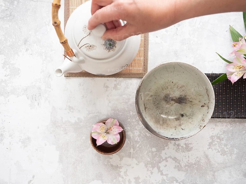 Teapot with bamboo handle and teacup ready for traditional tea ceremony preparation