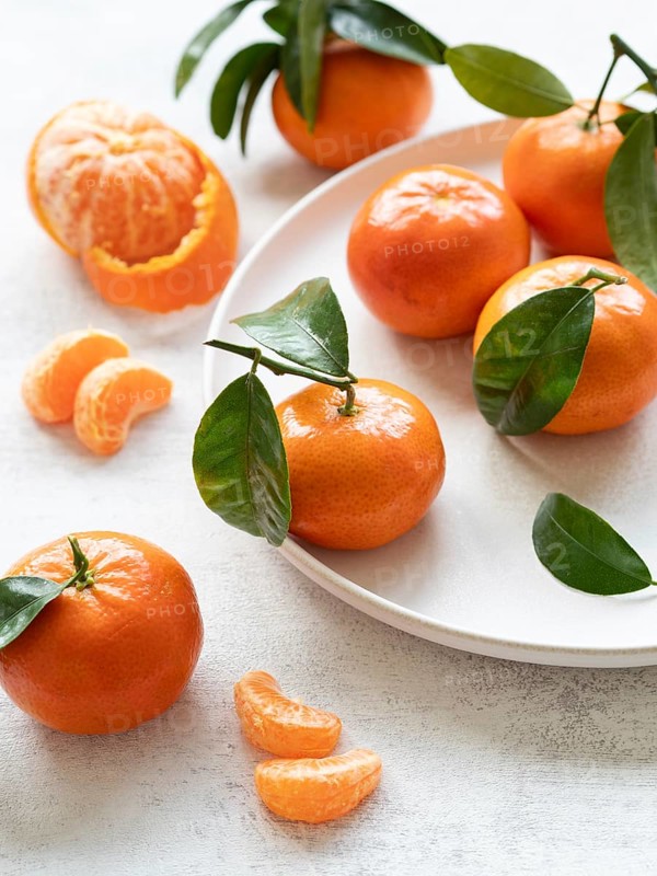 Vibrant tangerines with green leaves, showcasing freshness and citrusy appeal, perfect for healthy eating and seasonal recipes