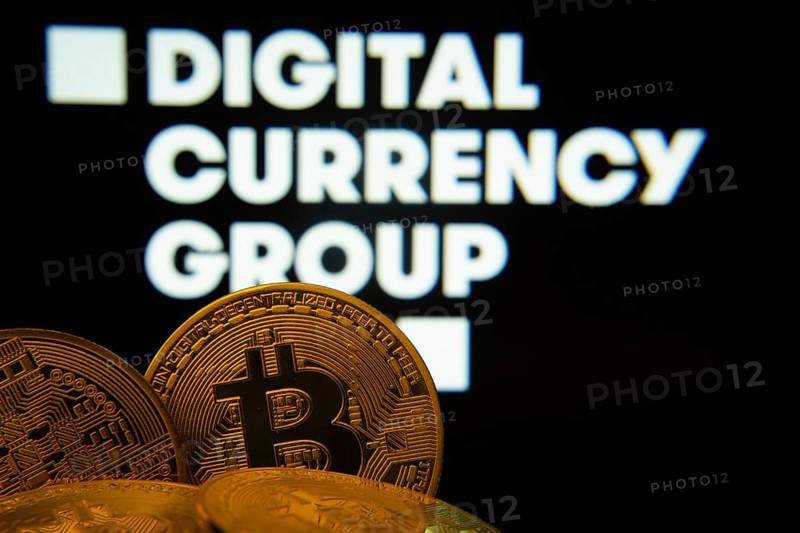Dhaka, Bangladesh- 03 Oct 2025: Close-up of Bitcoin coins with the digital currency group logo visible on a screen in the background