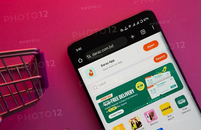 Dhaka, Bangladesh- 03 Oct 2025: A smartphone displaying the Daraz website with a shopping cart is shown on a vibrant background