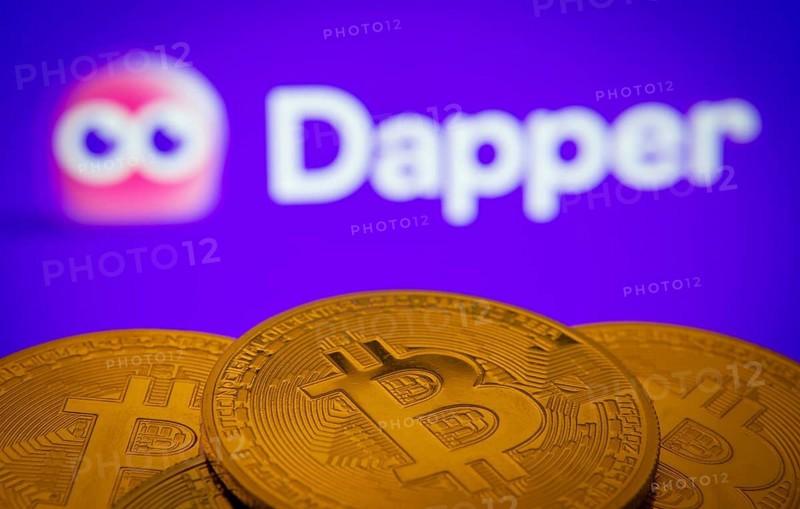 Dhaka, Bangladesh- 03 Oct 2025: Close-up of Bitcoin coins with the Dapper logo visible on a screen in the background