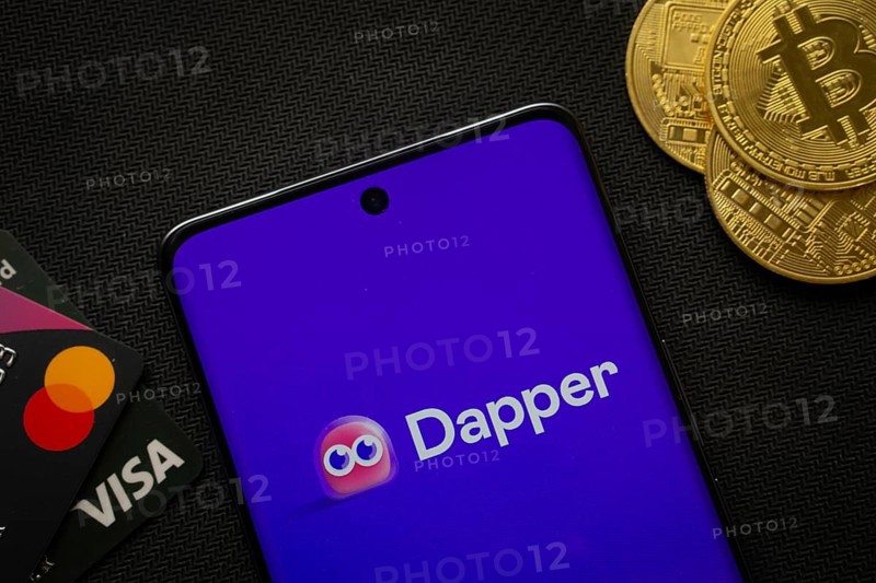 Dhaka, Bangladesh- 03 Oct 2025: Smartphone displaying Dapper logo surrounded by Bitcoin coins and payment cards