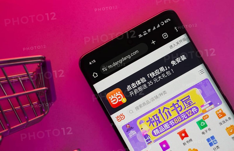 Dhaka, Bangladesh- 23 June 2025: A smartphone displaying the Dangdang.com website with a shopping cart is shown on a vibrant background