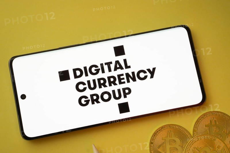 Dhaka, Bangladesh- 03 Oct 2025: Digital currency group logo on smartphone screen near Bitcoin coin and QR code on yellow background
