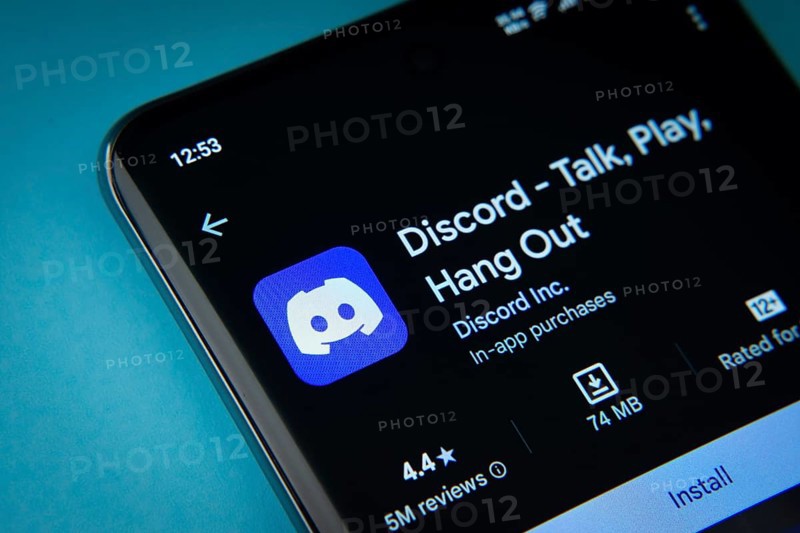 Dhaka, Bangladesh- 03 Oct 2025: On a blue surface, a smartphone displays the Discord app within the Google Play Store