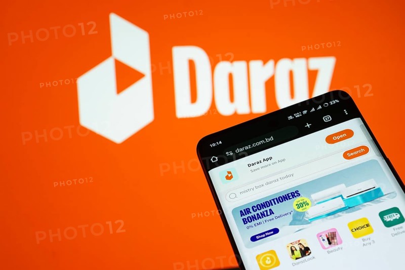 Dhaka, Bangladesh- 03 Oct 2025: Smartphone displaying Daraz web interface against Daraz logo background