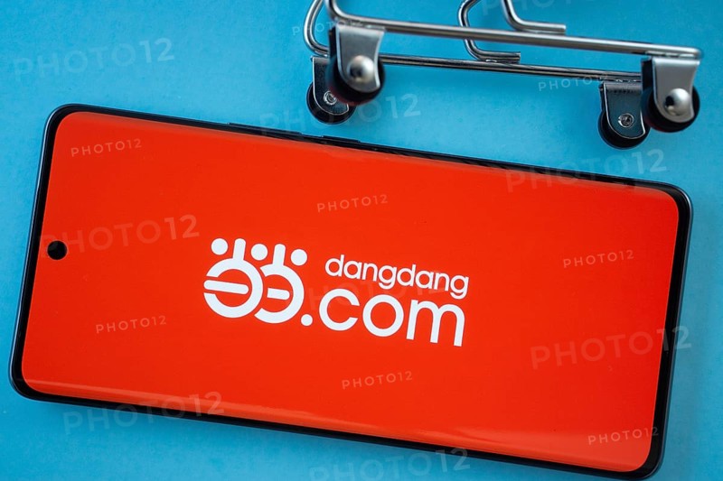 Dhaka, Bangladesh- 03 Oct 2025: Smartphone screen showing the Dangdang.com logo with shopping cart wheels on a blue background