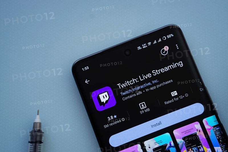 Dhaka, Bangladesh- 30 Sep 2025: On a blue surface, a smartphone displays the Twitch app within the Google Play Store