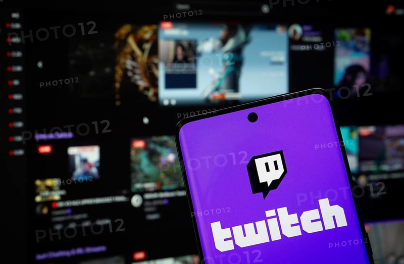 Dhaka, Bangladesh - Twitch 2025: The logo of the Twitch is displayed on a smartphone screen, and the website Twitch is visible on a computer screen in the background
