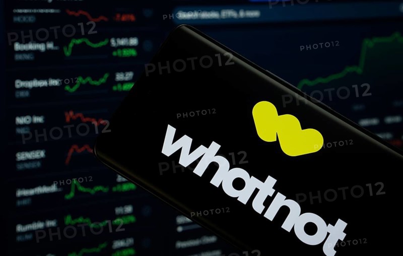 Dhaka, Bangladesh- 17 Sep 2025: Whatnot logo is displayed on a smartphone screen, with a stock graph webpage visible on a computer screen in the background
