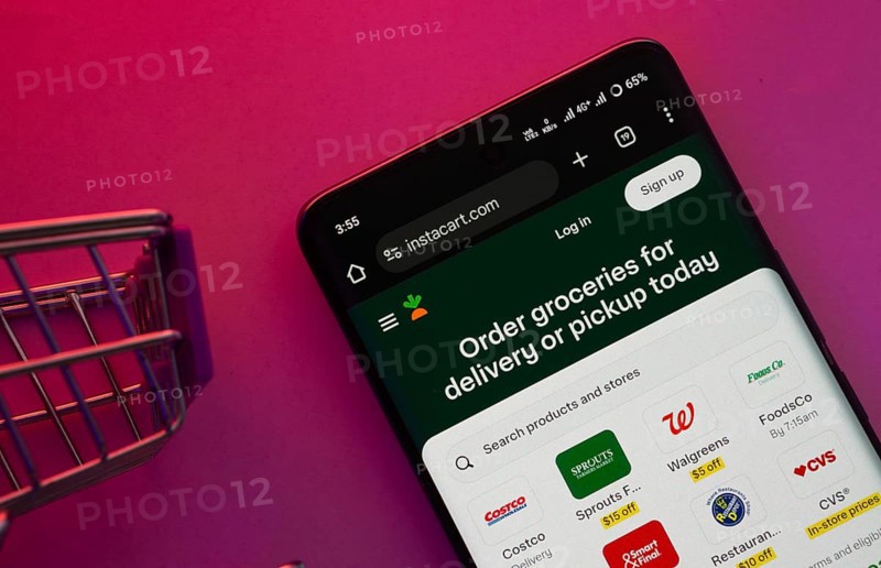 Dhaka, Bangladesh- 23 June 2025: A smartphone displaying the Instacart website with a shopping cart is shown on a vibrant background