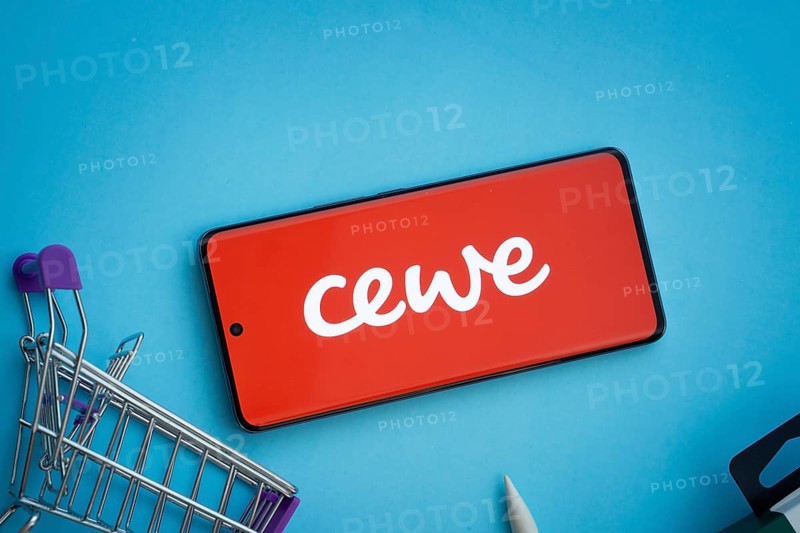 Dhaka, Bangladesh- 03 July 2025: Smartphone displaying Cewe logo with shopping cart on a blue background