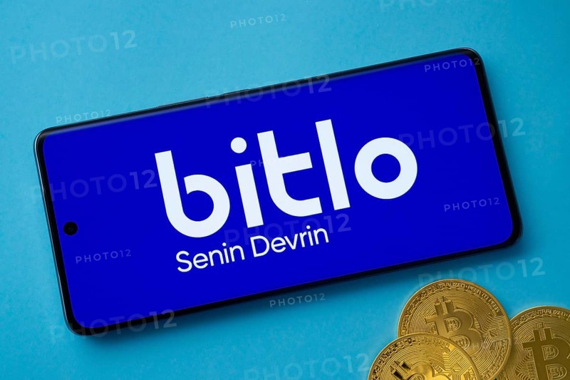 Dhaka, Bangladesh- 03 Sep 2025: Bitlo logo on smartphone screen near Bitcoin coin and QR code on blue background