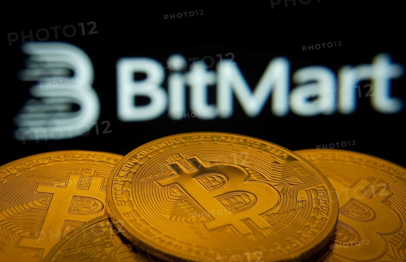 Dhaka, Bangladesh- 03 Sep 2025: Close-up of Bitcoin coins with the Bitmart logo visible on a screen in the background